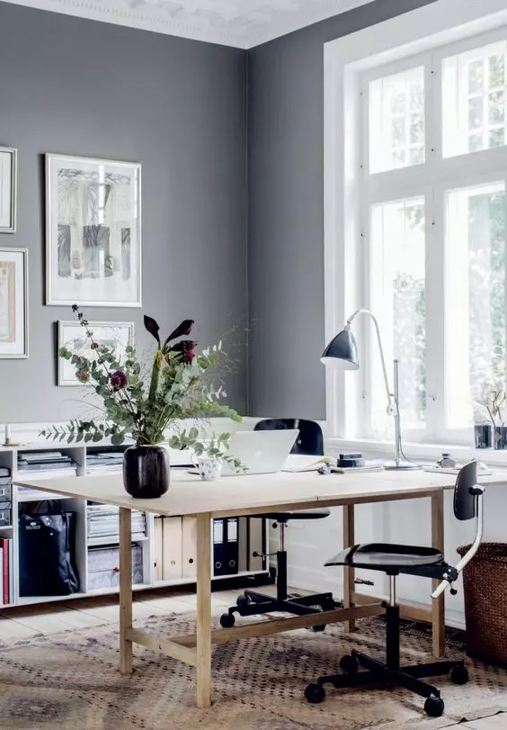 Scandinavian-home-office-with-a-wooden-desk-black-chairs-a-gallery-wall-a-black-lamp-a-storage-unit-and-a-rug Home Office